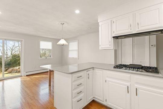kitchen featuring baseboard heating, stainless steel gas cooktop, white cabinetry, light wood-type flooring, and light countertops