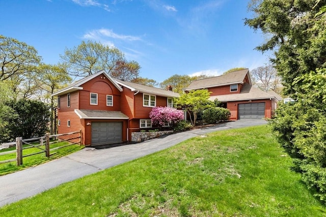 view of front of home featuring driveway, a chimney, and a garage