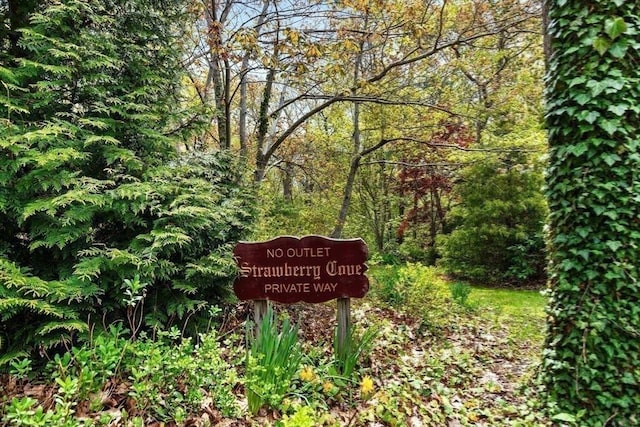 community / neighborhood sign featuring a forest view