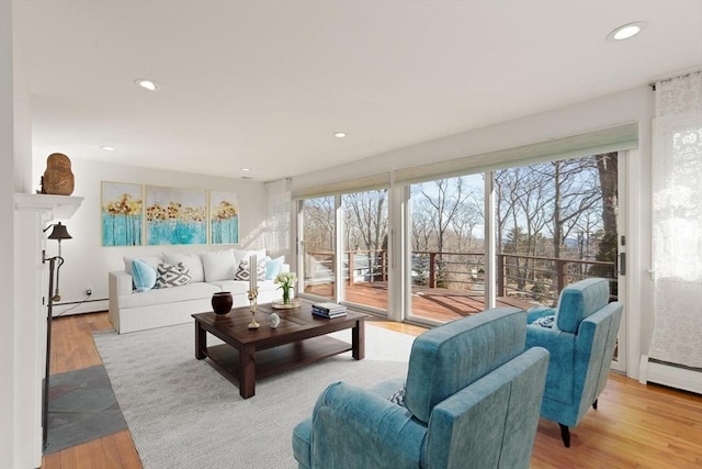 living room with baseboard heating, wood finished floors, and recessed lighting