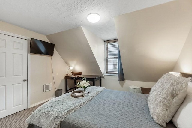 bedroom with a textured ceiling and carpet