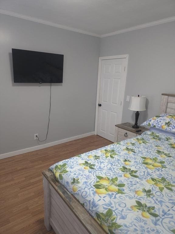 bedroom featuring ornamental molding and wood-type flooring