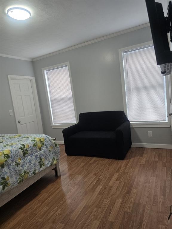 bedroom featuring multiple windows, ornamental molding, and dark hardwood / wood-style floors