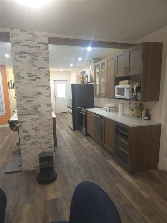 kitchen featuring crown molding, appliances with stainless steel finishes, and dark hardwood / wood-style floors