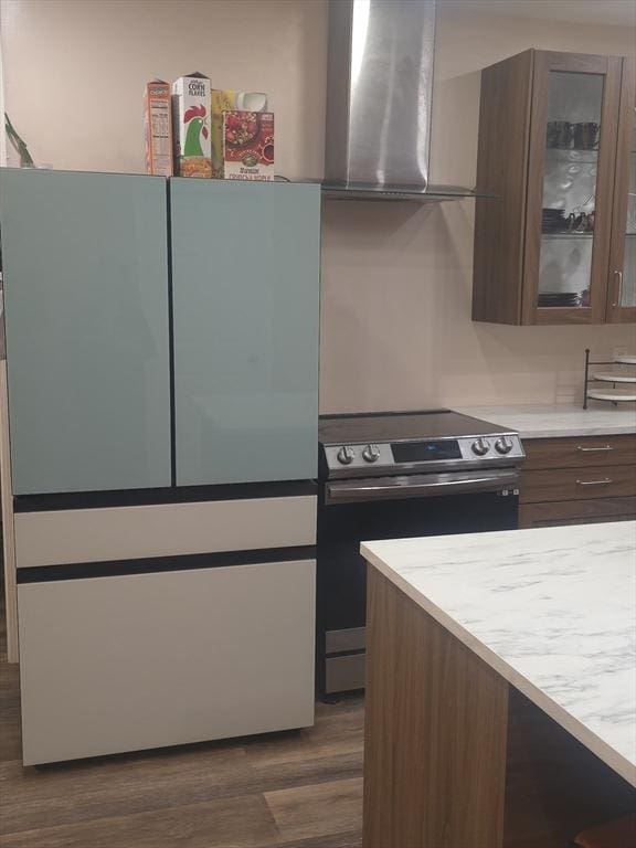 kitchen featuring dark brown cabinets, range hood, dark hardwood / wood-style floors, and stainless steel electric range oven