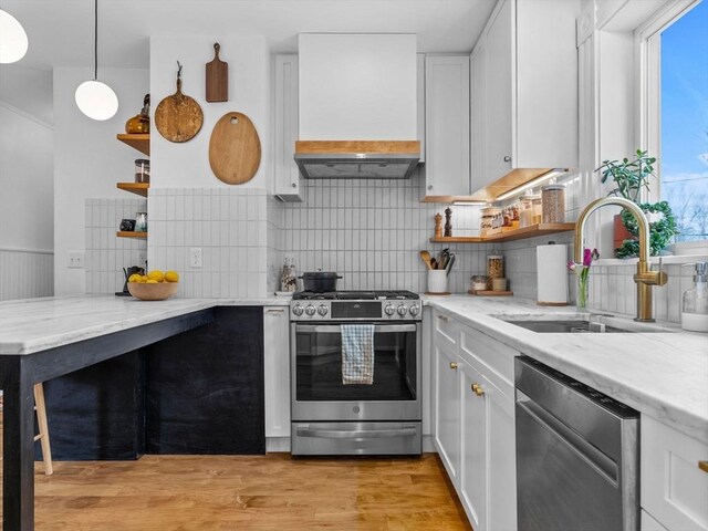 kitchen featuring a sink, open shelves, appliances with stainless steel finishes, custom exhaust hood, and white cabinets