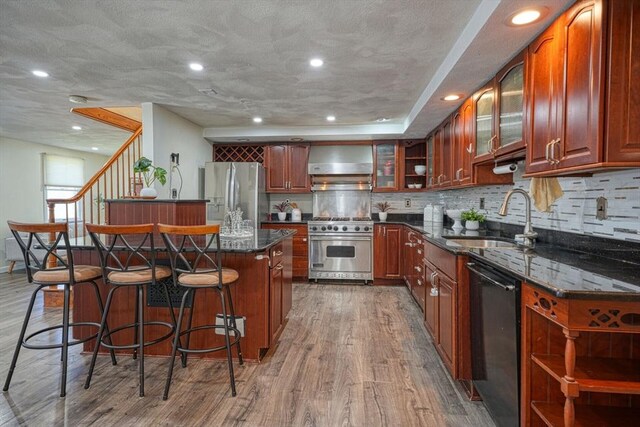 20 Fernglade Rd, Burlington, MA 01803 - kitchen featuring wall chimney range hood, a breakfast bar area, wood finished floors, a sink, and stainless steel appliances