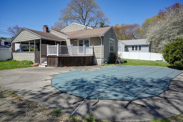 20 Fernglade Rd, Burlington, MA 01803 - rear view of house with a wooden deck, fence, roof with shingles, a chimney, and a fenced in pool