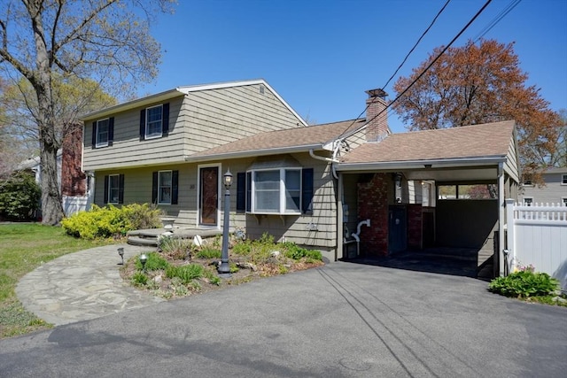 20 Fernglade Rd, Burlington, MA 01803 - view of front of home featuring fence, a chimney, an attached carport, and driveway