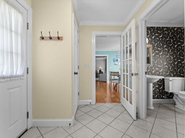 foyer entrance with light tile patterned flooring, baseboards, wallpapered walls, crown molding, and french doors