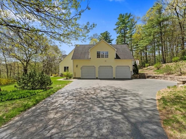 view of side of home with driveway, a garage, and roof with shingles