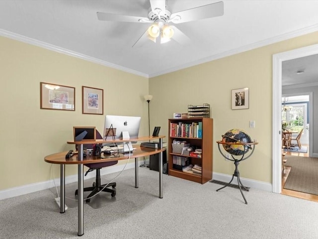 carpeted office space featuring crown molding, baseboards, and ceiling fan