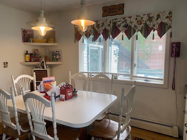 dining space with hardwood / wood-style floors and baseboard heating