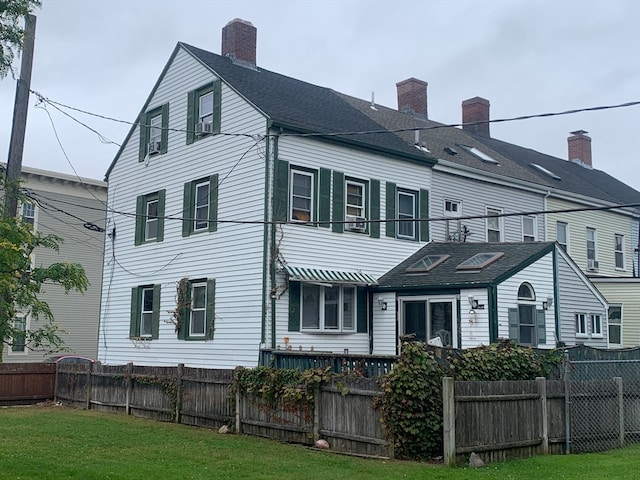 rear view of property with a lawn