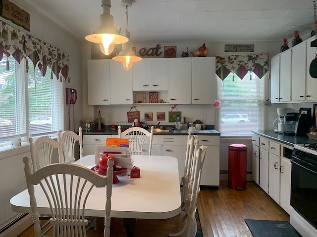 kitchen featuring white range, hardwood / wood-style flooring, hanging light fixtures, and white cabinets