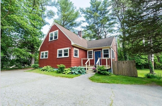 290 E St, Westwood, MA 02090 - view of front facade featuring a chimney, a shingled roof, and driveway