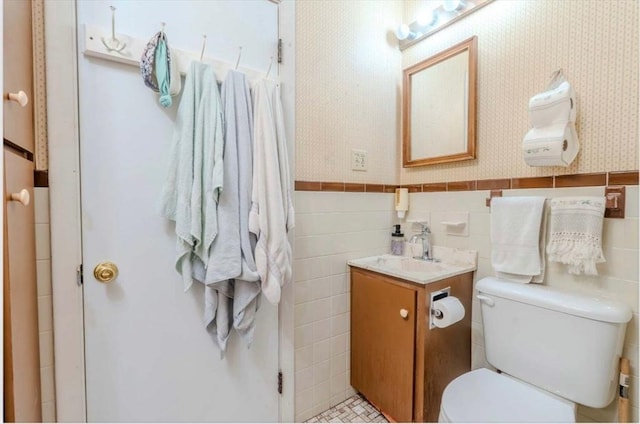 290 E St, Westwood, MA 02090 - bathroom featuring toilet, vanity, tile walls, wainscoting, and wallpapered walls