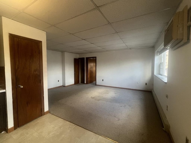 carpeted empty room with a drop ceiling