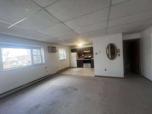 interior space featuring a drop ceiling, a wall mounted air conditioner, light carpet, and baseboard heating