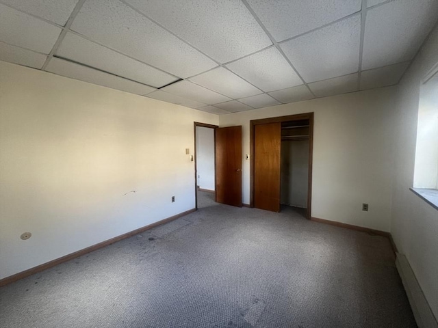 unfurnished bedroom with carpet flooring, a closet, and a drop ceiling