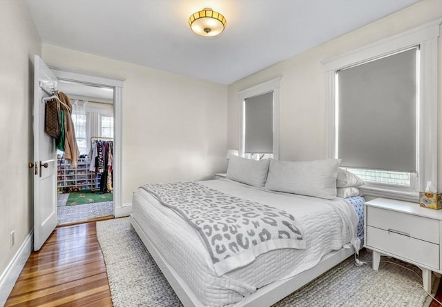 bedroom with access to exterior and hardwood / wood-style flooring