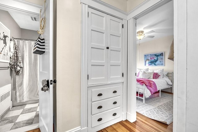 bathroom with radiator, ceiling fan, and hardwood / wood-style flooring