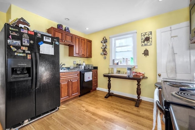 kitchen with black appliances, light hardwood / wood-style floors, and sink