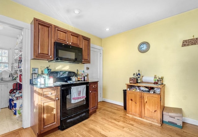 kitchen with light wood-type flooring and black appliances