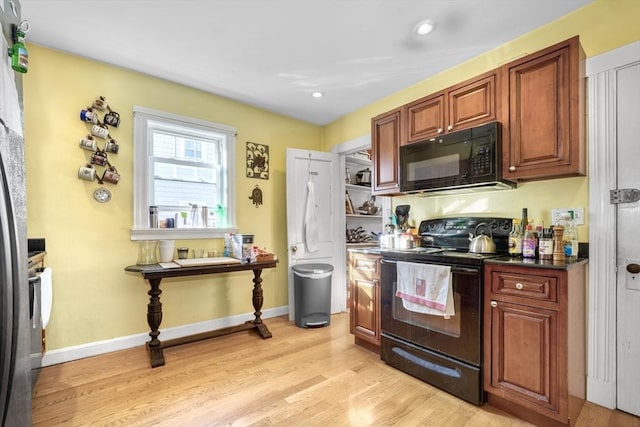 kitchen with black appliances and light hardwood / wood-style floors