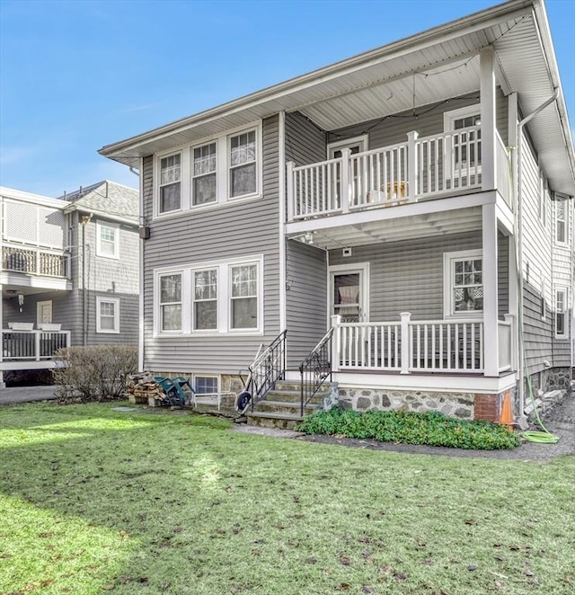 back of property with a lawn and a balcony