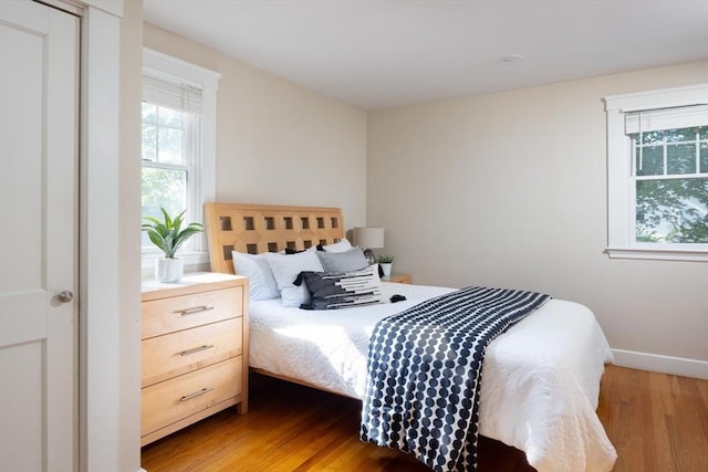 bedroom featuring wood finished floors and baseboards