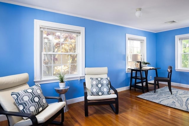 sitting room featuring baseboards, wood finished floors, and ornamental molding