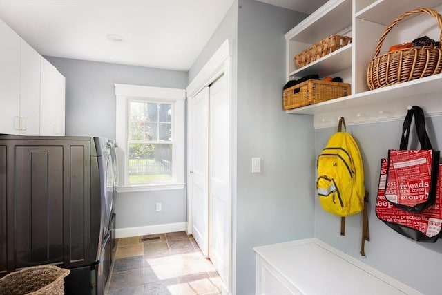 mudroom featuring dark stone finish flooring and baseboards