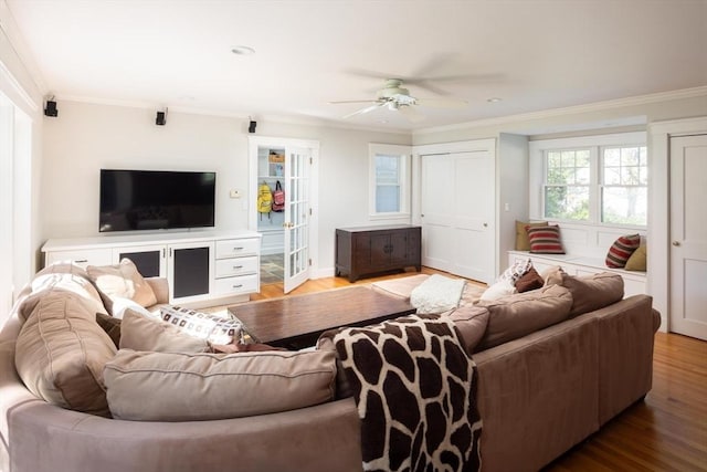 living room with crown molding, ceiling fan, and light wood-type flooring