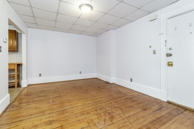 unfurnished room featuring a drop ceiling and light hardwood / wood-style flooring