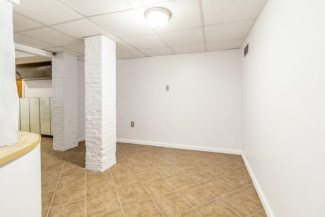 basement featuring tile patterned floors and a drop ceiling