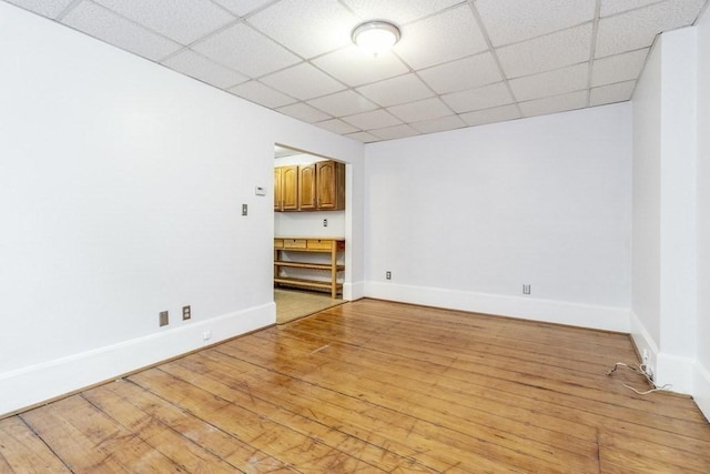 unfurnished living room with light hardwood / wood-style floors and a paneled ceiling