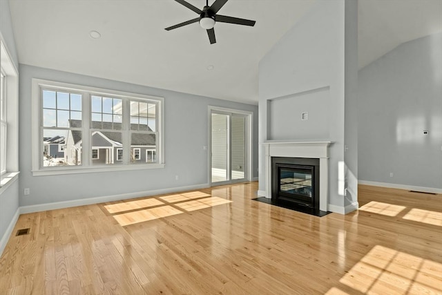 unfurnished living room with high vaulted ceiling, ceiling fan, and light hardwood / wood-style flooring