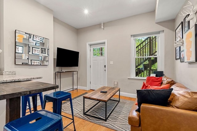 living area with baseboards, recessed lighting, and wood finished floors