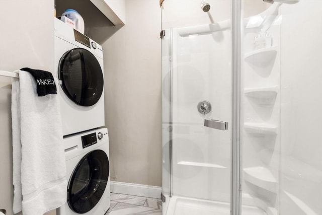 interior space featuring laundry area, baseboards, marble finish floor, and stacked washer / drying machine