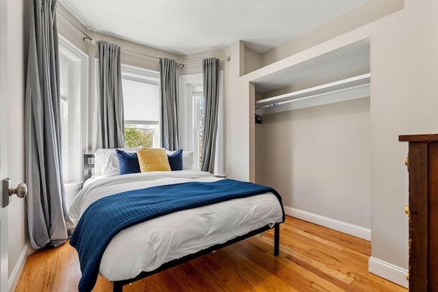 bedroom with baseboards and wood finished floors