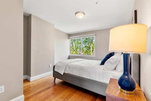 bedroom with baseboards and light wood-style flooring