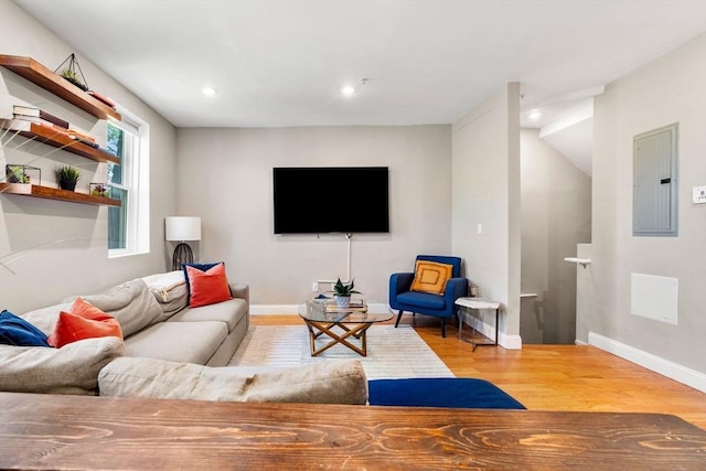 living area featuring baseboards, recessed lighting, wood finished floors, and electric panel
