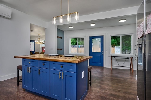 3030 Main St, Palmer, MA 01009 - kitchen featuring wooden counters, blue cabinetry, a kitchen bar, a wall unit AC, and dark wood-style floors