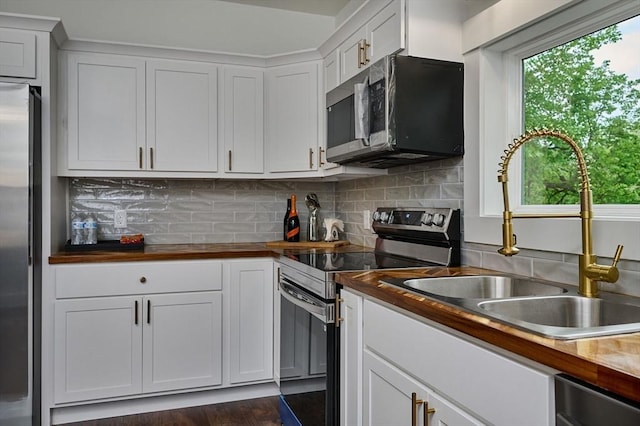 3030 Main St, Palmer, MA 01009 - kitchen featuring appliances with stainless steel finishes, wood counters, white cabinets, backsplash, and dark wood-style floors