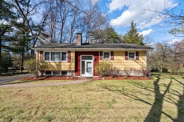 raised ranch with a chimney and a front lawn
