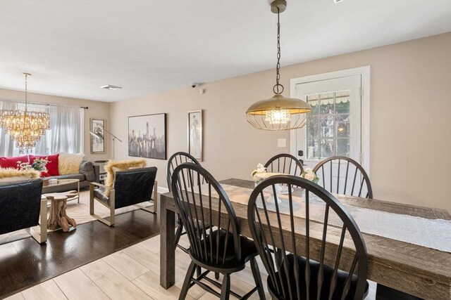 dining area featuring light wood-style floors and a chandelier