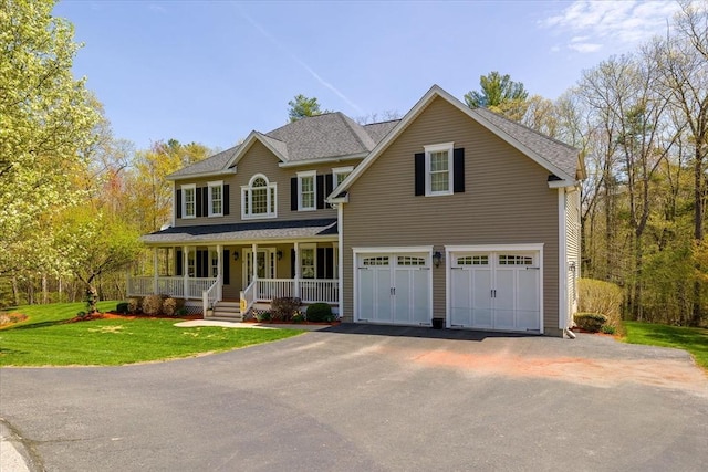 view of front of home featuring a garage, covered porch, a front yard, and aphalt driveway