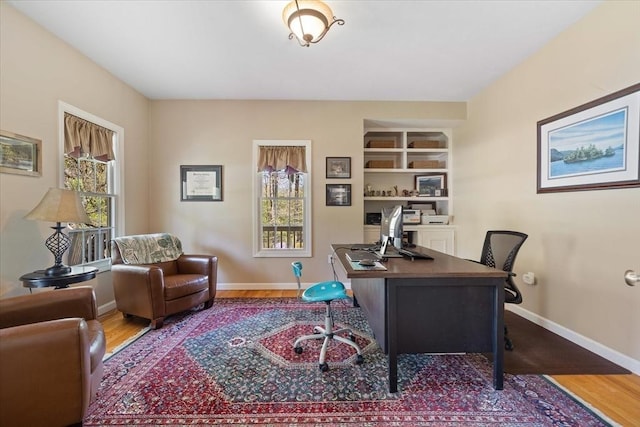 office featuring baseboards, wood finished floors, and a wealth of natural light