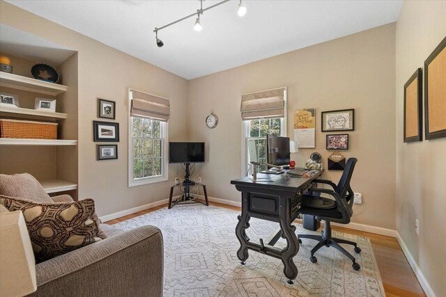 office space with baseboards, wood finished floors, and a wealth of natural light